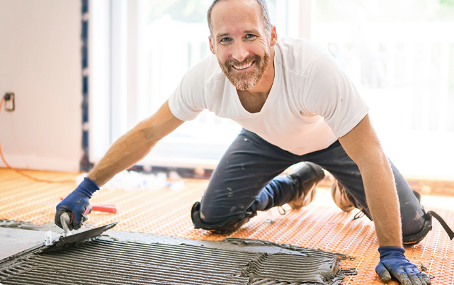 Professionele tegelzetter die tegels lijmt tijdens training Lijmen van Tegels bij De Afbouwacademie